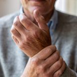 Senior man with arthritis rubbing hands